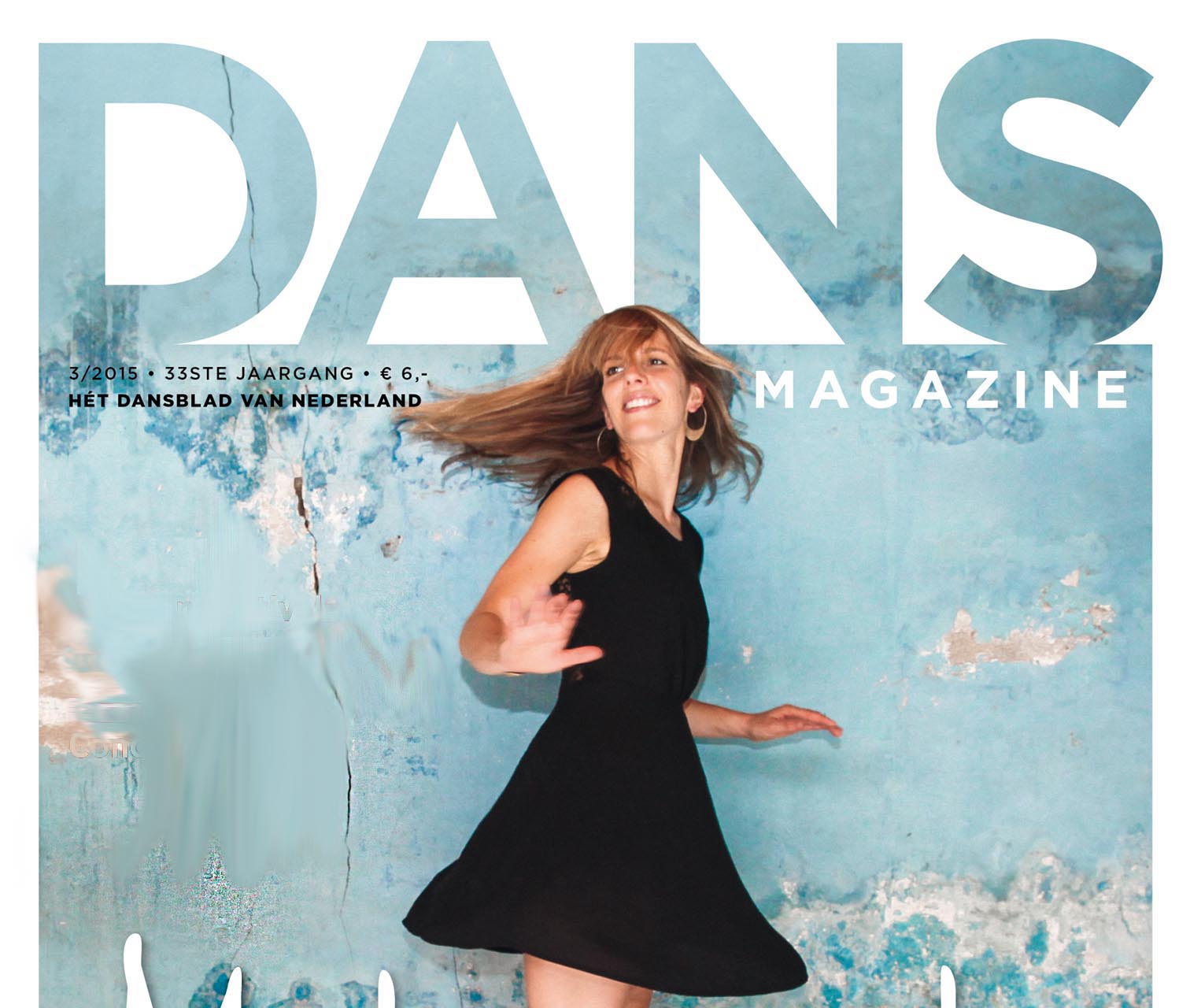 Relinde Moors on the cover of DANS Magazine in a black dress against a blue wall